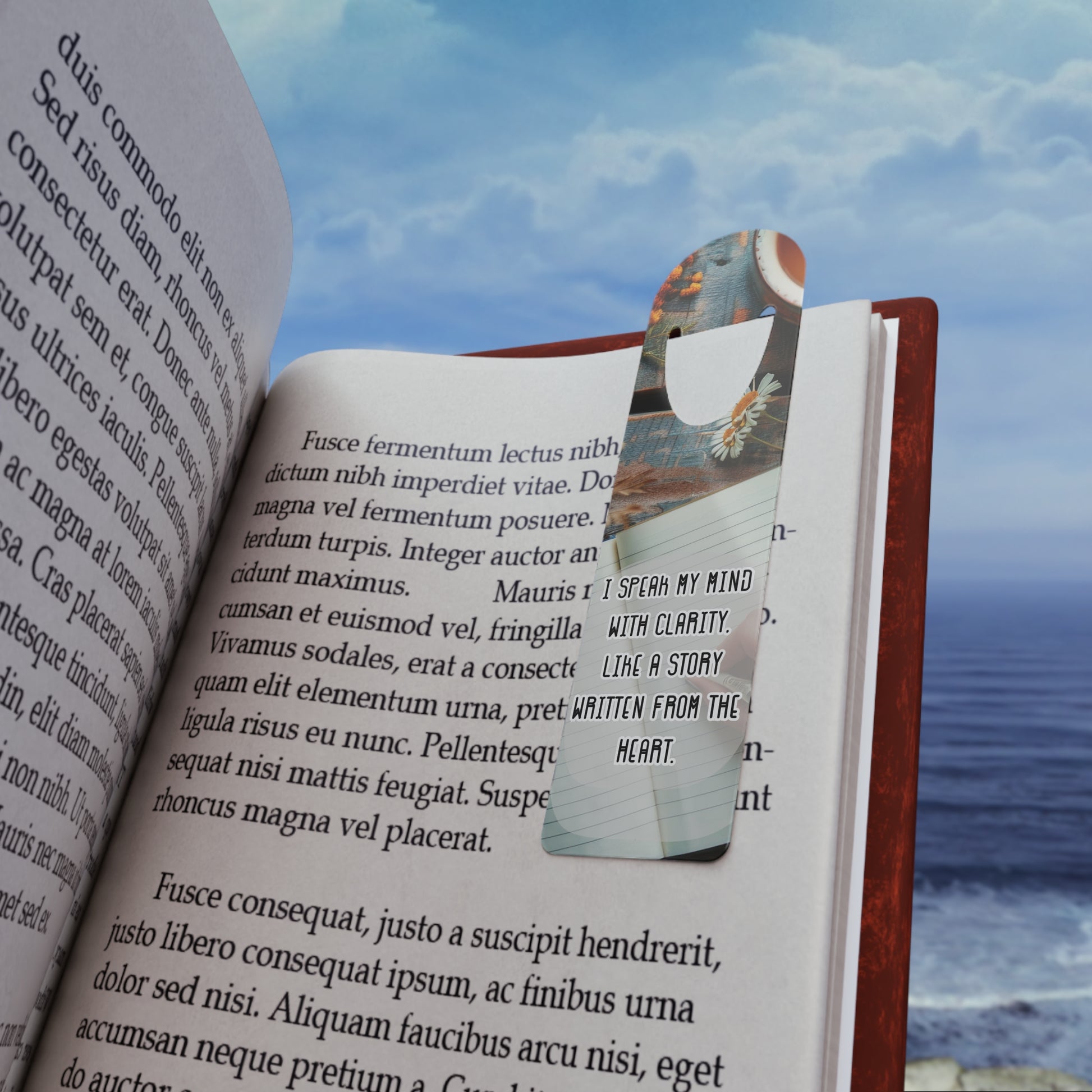 Open book with a bookmark featuring a butterfly design against a scenic background.
