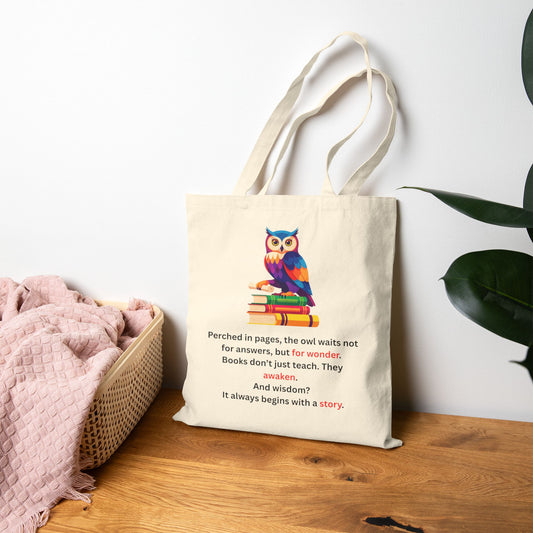 Tote bag with owl design and quote on a wooden surface with a plant in the background