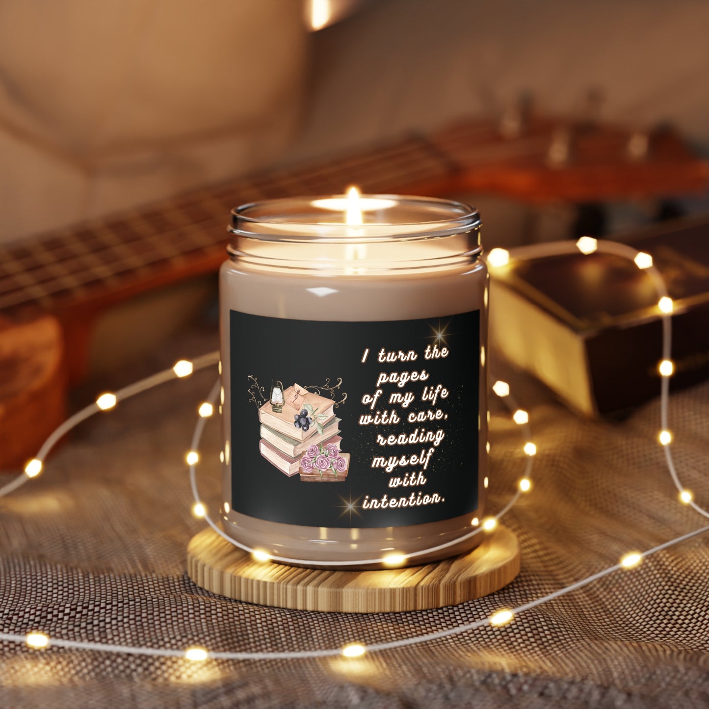 Candle in a jar with a decorative label on a wooden coaster, surrounded by string lights and a guitar in the background.
