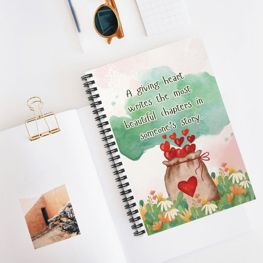 Notebook with heart-themed cover and motivational quote on a white surface